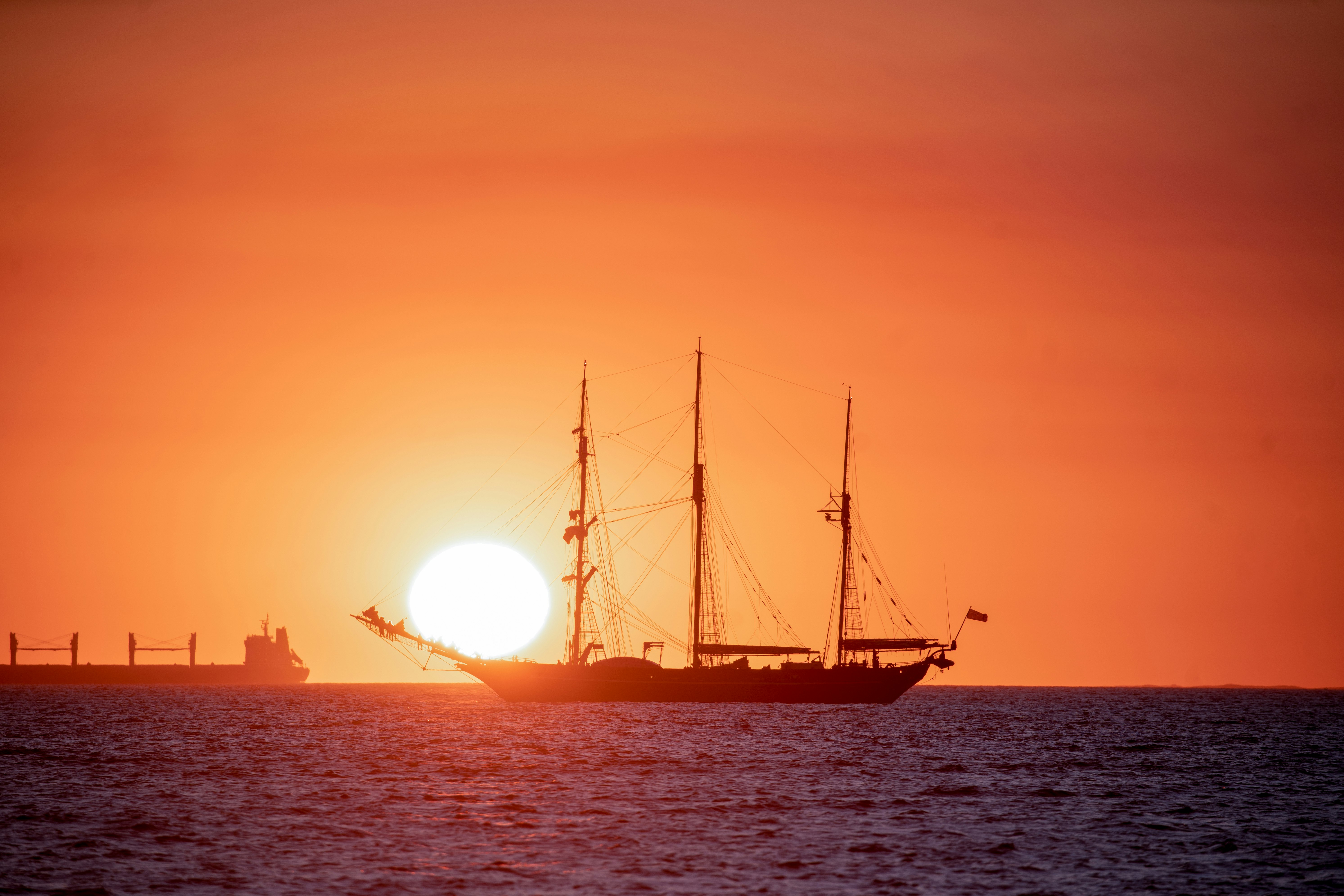 silhouette of ship on sea during sunset